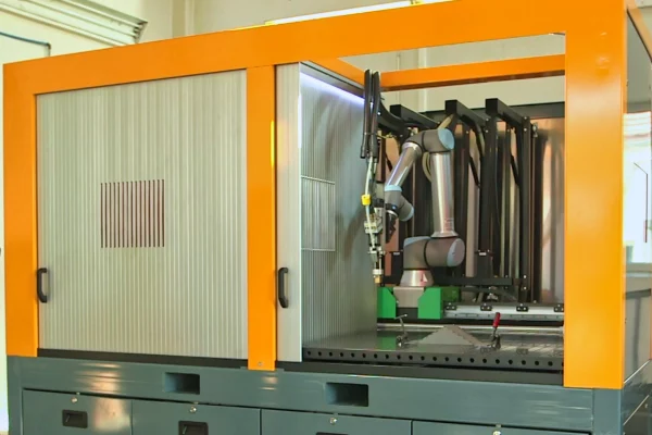 Roboterzelle 3 Roboterzelle mit einem Universal Robots UR10e. Zwei Türen für die Arbeitsbereiche. Der Roboter steh auf einer Linearachse